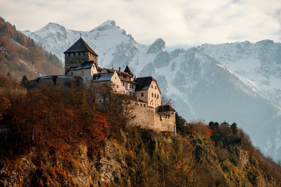 Vaduz Castle in Liechtenstein, with snow-covered mountains behind it.